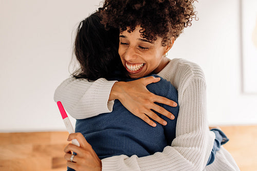 Mothers-to-be celebrating a positive pregnancy test