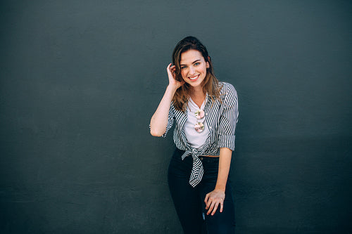 Portrait of a woman standing against a wall
