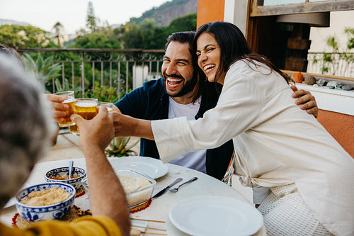 Happy family enjoying a meal and drinks on a sunny outdoor terrace