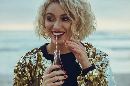 Woman drinking cold drink at the beach