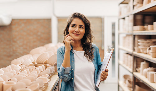 Female ceramist thinking of new ideas for her shop