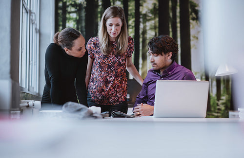 Young team of designers discussing magazine publication