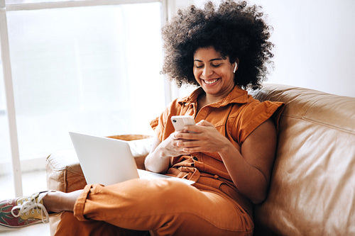 Cheerful businesswoman using a smartphone while working in an office