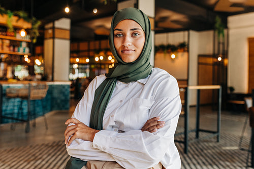 Confident Muslim woman looking at the camera in a cafe