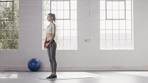Woman doing cobra and downward facing dog pose in yoga studio