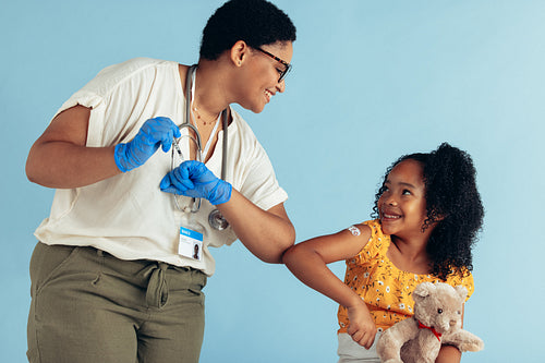 Girl giving elbow bump to doctor after vaccination
