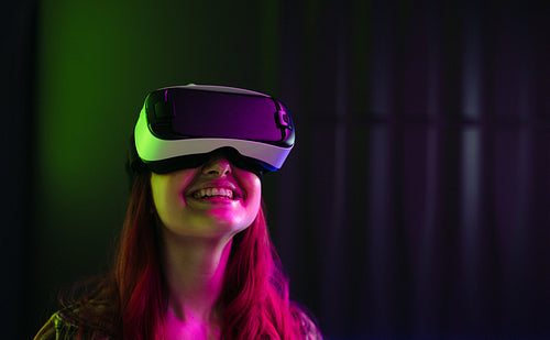 Immersed in Digital Joy: Woman Smiling as She Explores Virtual Reality