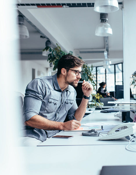 Thoughtful businessman looking at monitor