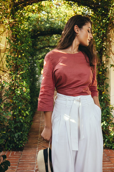 Elegant young woman standing in a plant tunnel