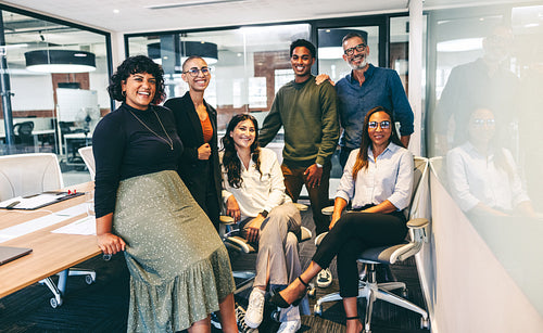 Group of happy businesspeople smiling at the camera in a boardroom