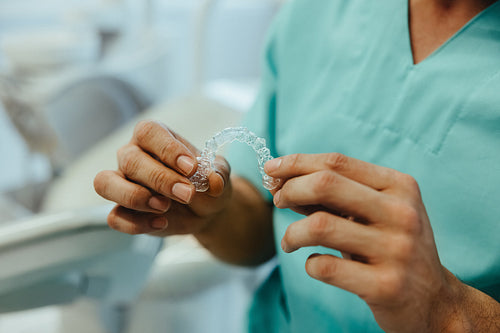 Hand holds a dental aligner for orthodontic consultation in the clinic