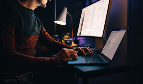 Marketing professional typing on his laptop in his home office