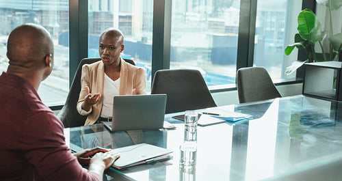 African businesswoman discussing plans with a colleague in a corporate office