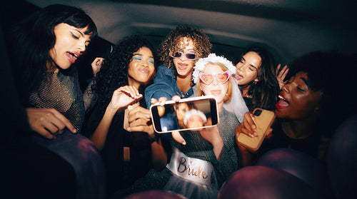 Group of women celebrating a bachelorette party in the back of a cab