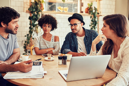 Creative team meeting in a coffee shop for business discussion