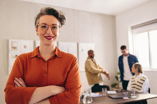 Mature businesswoman smiling at the camera while standing in an office