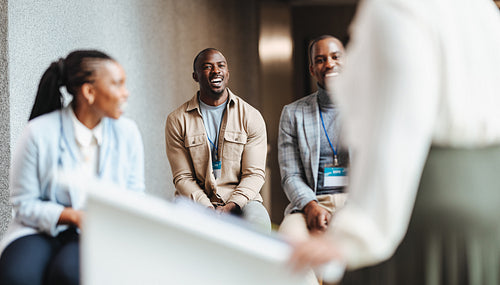 Happy professionals engaging in a workshop at a conference, exchanging ideas and learning together