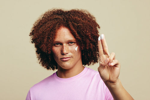 Portrait of a handsome and youthful man trying a new beauty product on his face