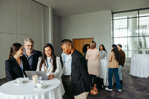 Business professionals engaging in lively discussions during a conference tea break