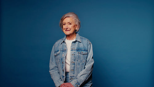 Happy senior woman in denim jacket smiling at camera