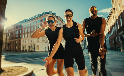 Running club friends having fun together on a city street after fitness training