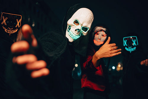 People in glowing masks enjoying a night scene with mysterious atmosphere
