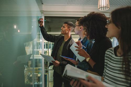 Student writing on board during class