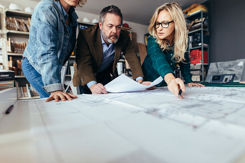 Team of architects working on construction drawing