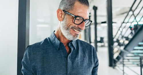 Experienced businessman smiling cheerfully in an office