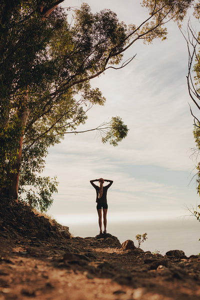 Female runner relaxing on mountain peak