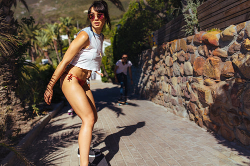 Beautiful woman skating on ocean walk front