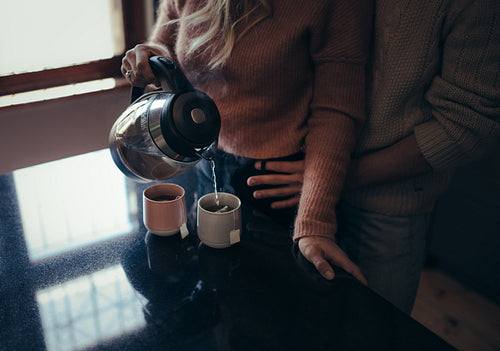 Romantic man and woman in kitchen making coffee.