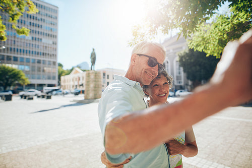 Affectionate senior tourists taking a selfie outdoors