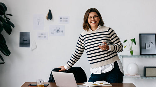 Her woman-led office moment shows a smiling professional on a break with a laptop at the desk
