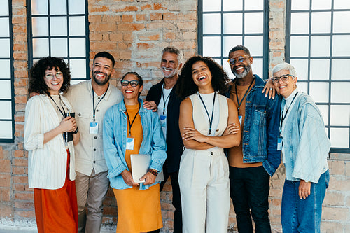 Diverse and happy small business team posing together in a sleek and modern office environment
