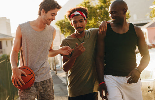 Basketball guys walking on pavement with the ball