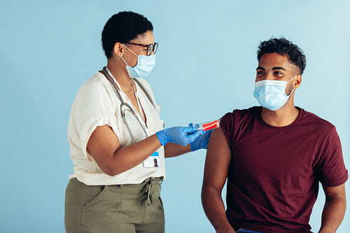 Doctor offering candy to man after vaccination