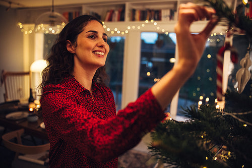 Woman happily decorating Christmas tree