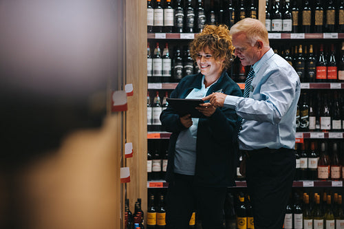 Wine shop employees taking inventory