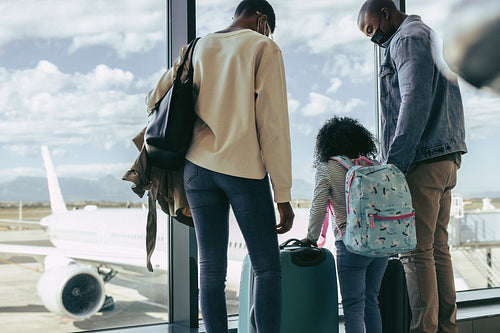 Tourist family waiting at airport with luggage