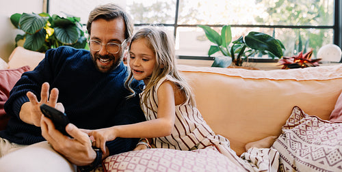 Father and daughter watching a video on a phone