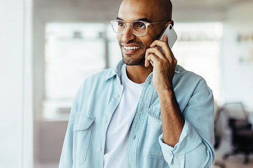Black business man making a phone call in his workplace