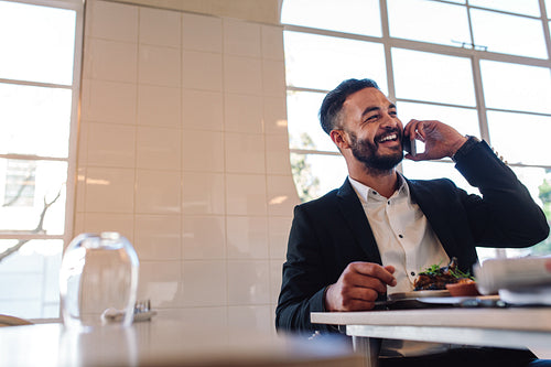 Businessman at restaurant making a phone call