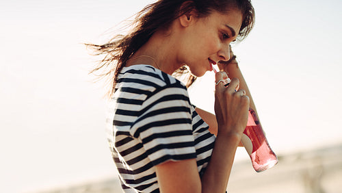 Woman walking outdoors and having a soft drink