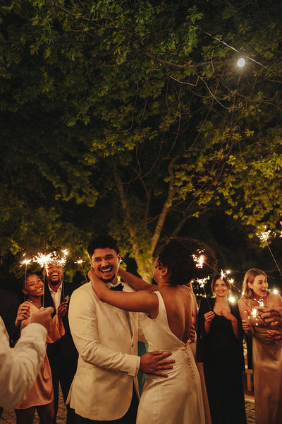 Joyful wedding celebration with sparklers in an outdoor evening garden setting