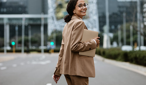 Smiling businesswoman walking on city street