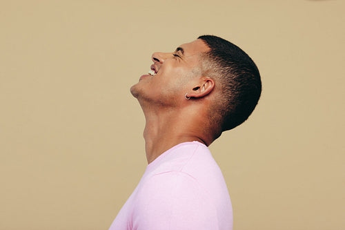Young man smiling as he shows his beautiful radiant skin in a studio