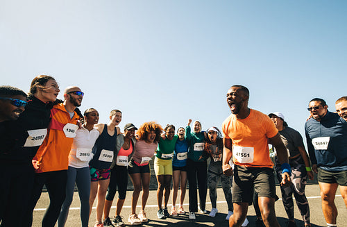 Diverse group of runners cheering before marathon race