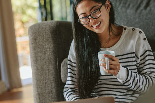 Asian woman relaxing at home using laptop