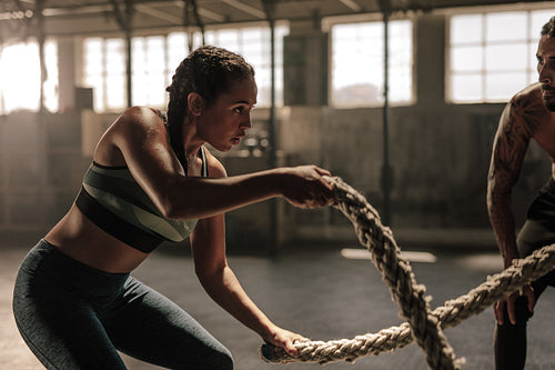 Woman doing battle rope workout at gym